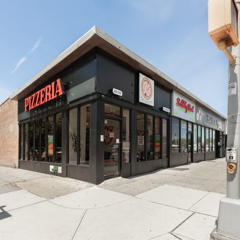 Exterior of a black pizzeria building with large windows and a red "PIZZERIA" sign on a sunny day.
